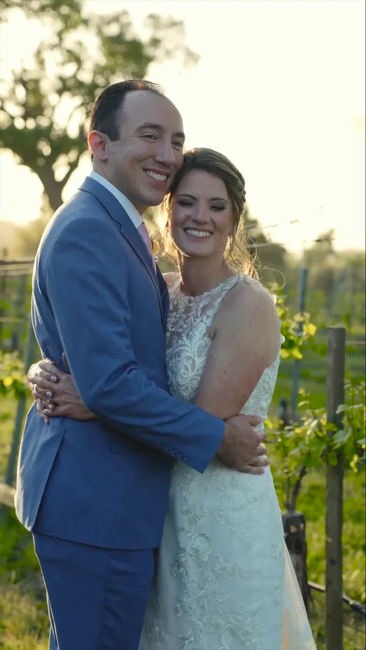 Kaylah and Anthony embracing in a vineyard